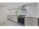 Modern kitchen featuring gray countertops, stainless steel appliances, and light gray tile backsplash at 1887 Shalimar Dr, Atlanta, GA 30345