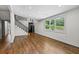 Bright living room featuring hardwood floors, natural light from a large window, and a modern staircase at 1887 Shalimar Dr, Atlanta, GA 30345