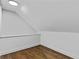 An unfinished room with dark hardwood floors, white trim, and angled ceiling and walls at 1887 Shalimar Dr, Atlanta, GA 30345