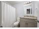 Bathroom featuring a shower-tub, grey vanity, and spiral staircase in the background at 2507 Albion Farm Way, Duluth, GA 30097