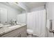Bathroom with granite countertops, white cabinets, framed mirror and shower with white curtain at 2507 Albion Farm Way, Duluth, GA 30097