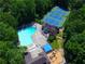 An aerial view shows a pool, tennis courts and playground, all surrounded by lush trees at 2628 Amberly Dr, Dunwoody, GA 30360