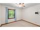 This bedroom features neutral carpet, ceiling fan, and window with blue curtains at 3802 Sw Knights Bridge Sw Rd, Lilburn, GA 30047