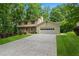 Traditional home featuring a lush green lawn, mature trees, and a two-car attached garage at 3802 Sw Knights Bridge Sw Rd, Lilburn, GA 30047