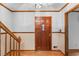 Welcoming foyer featuring a classic wood door, staircase, and wood floors at 3802 Sw Knights Bridge Sw Rd, Lilburn, GA 30047
