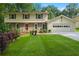 Charming two-story home with a manicured lawn, brick accents, and attached two-car garage at 3802 Sw Knights Bridge Sw Rd, Lilburn, GA 30047