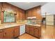 Well-lit kitchen with wood cabinets, a window overlooking the backyard, and hardwood floors at 3802 Sw Knights Bridge Sw Rd, Lilburn, GA 30047