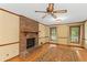 Inviting living room with a brick fireplace, hardwood floors, and large windows at 3802 Sw Knights Bridge Sw Rd, Lilburn, GA 30047