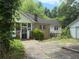 View of a vintage bungalow home with sunroom and detached garage at 602 Hamilton Holmes Dr, Atlanta, GA 30318