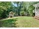 Lush backyard featuring a playhouse, swing set, trampoline, and mature trees at 1448 Diamond Head Cir, Decatur, GA 30033