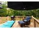 Relaxing back deck with grill, chair, ottoman and umbrella, ideal for outdoor cooking and enjoying wooded views at 200 Scouts Ridge Dr, Covington, GA 30016