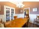 View of formal dining room with hardwood floors and staircase through french doors at 200 Scouts Ridge Dr, Covington, GA 30016