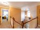 Well-lit hallway features neutral carpeting, wooden railings, and a glimpse into the adjacent bedroom at 200 Scouts Ridge Dr, Covington, GA 30016