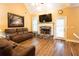 Cozy living room featuring a stone fireplace, wood flooring, and a door leading to the yard at 200 Scouts Ridge Dr, Covington, GA 30016