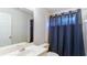 Bathroom featuring a white vanity, toilet, and shower with blue curtain at 251 Waterford Cove Dr, Suwanee, GA 30024
