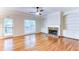 Living room has hardwood floors, built-in shelving, a ceiling fan, and a stone fireplace at 251 Waterford Cove Dr, Suwanee, GA 30024