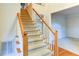 Long view of staircase with carpeted steps, wood railing, and light gray walls at 251 Waterford Cove Dr, Suwanee, GA 30024