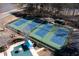 Aerial view of four well-maintained community tennis courts with blue playing surfaces and green borders at 251 Waterford Cove Dr, Suwanee, GA 30024