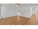 Open bedroom with wood-look flooring, neutral walls, bright windows, a ceiling fan, and an adjacent hallway at 2935 Leafwood Se Dr, Marietta, GA 30067