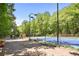 Brightly lit outdoor tennis court with a blue and green surface surrounded by trees at 2935 Leafwood Se Dr, Marietta, GA 30067