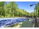 Outdoor tennis court with a blue and green surface and a net surrounded by trees at 2935 Leafwood Se Dr, Marietta, GA 30067