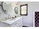 Bright bathroom features double vanity, marble countertop, stylish oval mirrors and a large window at 6715 Wright Rd, Sandy Springs, GA 30328
