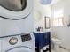 Charming bathroom features a stylish navy blue vanity, stackable washer/dryer, and a round mirror at 6715 Wright Rd, Sandy Springs, GA 30328