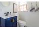 Charming half-bathroom featuring blue vanity with golden hardware and stylish decor at 6715 Wright Rd, Sandy Springs, GA 30328