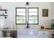 Modern kitchen with subway tile backsplash, farmhouse sink, stainless steel appliances, and open shelving at 6715 Wright Rd, Sandy Springs, GA 30328