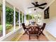 Inviting sunroom with wooden table and chairs, ceiling fan, and views of the lush green backyard at 6715 Wright Rd, Sandy Springs, GA 30328