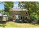 Backyard view of a two-story home with a deck, a grill and fenced yard shaded by mature trees at 4031 E Meadow Dr, Duluth, GA 30096