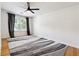Bright bedroom featuring hardwood floors, a modern ceiling fan, and large windows at 4031 E Meadow Dr, Duluth, GA 30096