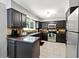 Well-lit kitchen featuring dark cabinetry, stainless steel appliances, and tile backsplash at 4031 E Meadow Dr, Duluth, GA 30096
