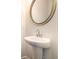 Close-up view of a pedestal sink with silver mirror and fixtures at 4627 Piston Sw Jct, Mableton, GA 30126