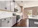 Stylish kitchen featuring gray cabinets, white subway tile backsplash, stainless steel appliances, and hardwood floors at 4627 Piston Sw Jct, Mableton, GA 30126