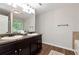 This primary bathroom features a double vanity, granite countertop, and wood grain tile flooring at 5414 Sycamore Rd, Oakwood, GA 30518