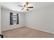 A bedroom with carpet flooring, ceiling fan, window, and neutral color palette creating a comfortable atmosphere at 5414 Sycamore Rd, Oakwood, GA 30518