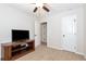 Bedroom featuring a ceiling fan, tv, open doors and neutral carpet flooring at 5414 Sycamore Rd, Oakwood, GA 30518