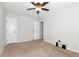 A carpeted bedroom with a ceiling fan, showing doors and blank walls, offering customization potential at 5414 Sycamore Rd, Oakwood, GA 30518
