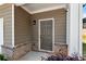 Inviting front entrance with brick accents and a stylish exterior light fixture at 5414 Sycamore Rd, Oakwood, GA 30518