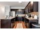 Well-lit kitchen features dark wood cabinets, stainless steel appliances, and granite countertops at 5414 Sycamore Rd, Oakwood, GA 30518