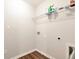 Bright laundry room with wood-look flooring, shelving, and utility connections, offering practicality and organization at 5414 Sycamore Rd, Oakwood, GA 30518