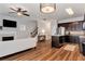 Cozy open-concept living space with a fireplace, staircase, kitchen, and modern fixtures at 5414 Sycamore Rd, Oakwood, GA 30518