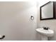 Classic powder room with a pedestal sink and dark framed mirror at 5414 Sycamore Rd, Oakwood, GA 30518
