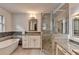 Bright bathroom with a soaking tub, granite countertop vanity and an elegant, glass enclosed shower at 1168 Atcheson Ln, Atlanta, GA 30338
