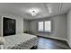 Bedroom with black double doors, a window, and hardwood floors, providing a simple, uncluttered design at 1168 Atcheson Ln, Atlanta, GA 30338