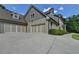View of a three-car garage featuring modern doors and a wide driveway surrounded by mature trees at 1168 Atcheson Ln, Atlanta, GA 30338