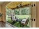 Inviting screened porch with seating area and view of the expansive lawn at 1168 Atcheson Ln, Atlanta, GA 30338