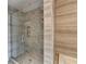 Close up of glass-enclosed shower with mosaic tiles and a hand-held shower head fixture at 1168 Atcheson Ln, Atlanta, GA 30338