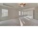 Expansive main bedroom featuring a tray ceiling, neutral decor, large windows, and plush carpeting at 2485 Dixon Pl, Lawrenceville, GA 30045